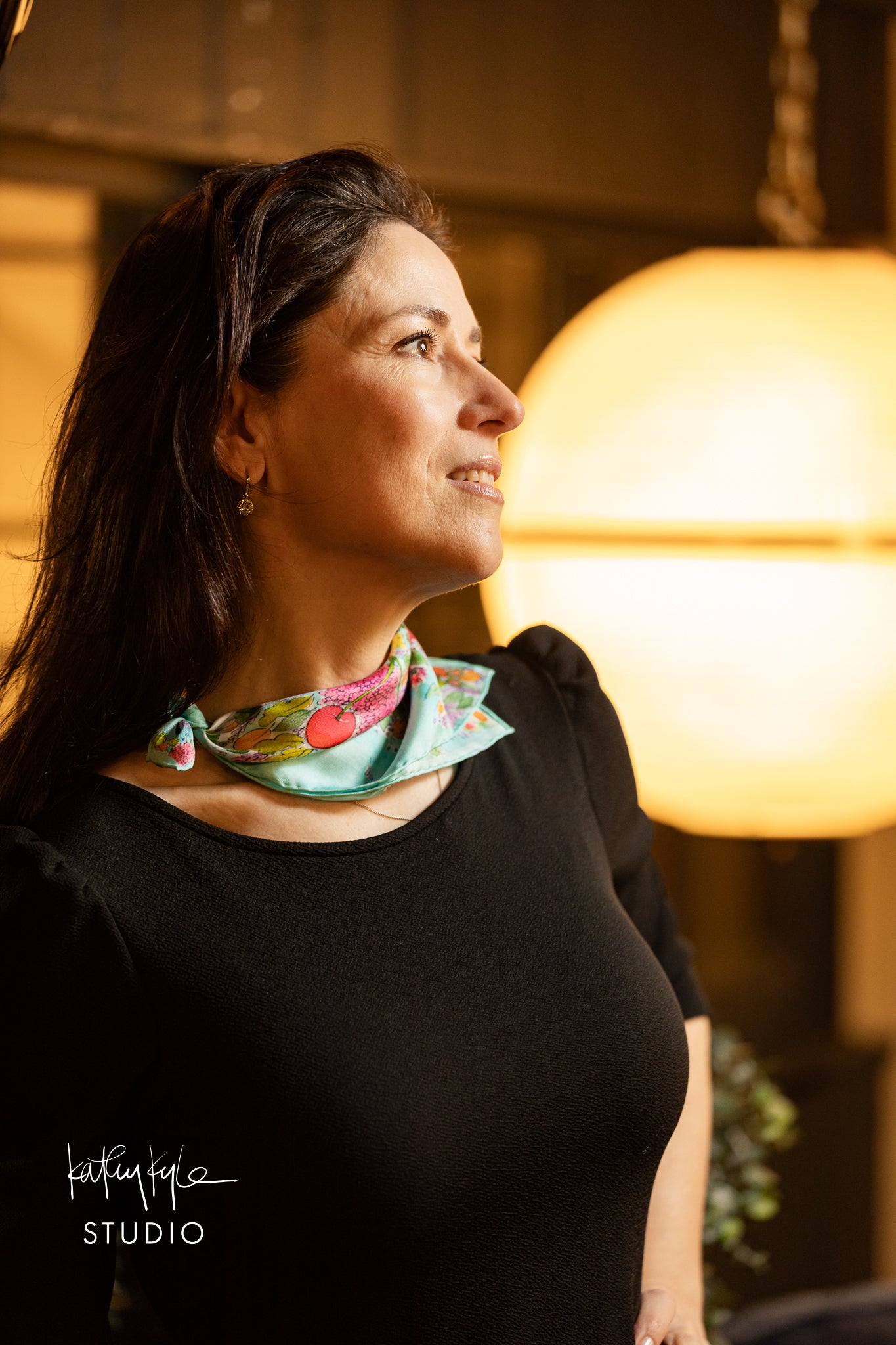 Woman wearing a colorful scarf in a warm-lit indoor setting